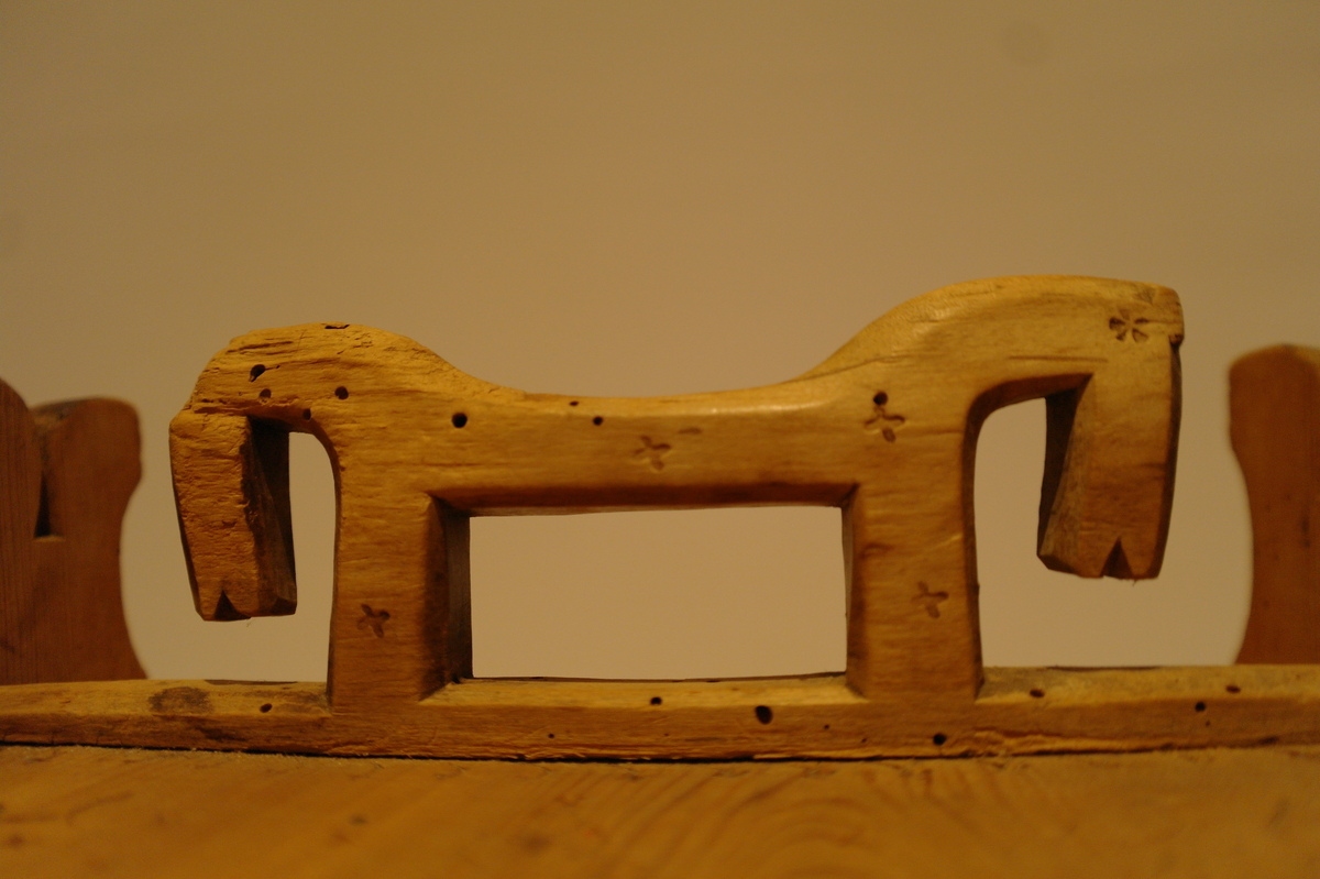 Lagga kar haldt saman av tre eineband stifta til karet med tre og metall stiftar. Bandane er kilt inn i kvarandre. Halvsirkelforma sviornamentikk på lok og kar. På kvar halvsirkel er det ei abstrakt blome. S-forma ornamentikk på karet. Øyra har firedelt utskåren topp. Kvart øyre har eit hol for å feste loket. Det eine holet er gjennomgåande. Handtaket på loket har form av to hester. Abstrakte blomeornamenter også på handtaket. Handtaket er felt inn i loket. I god stand