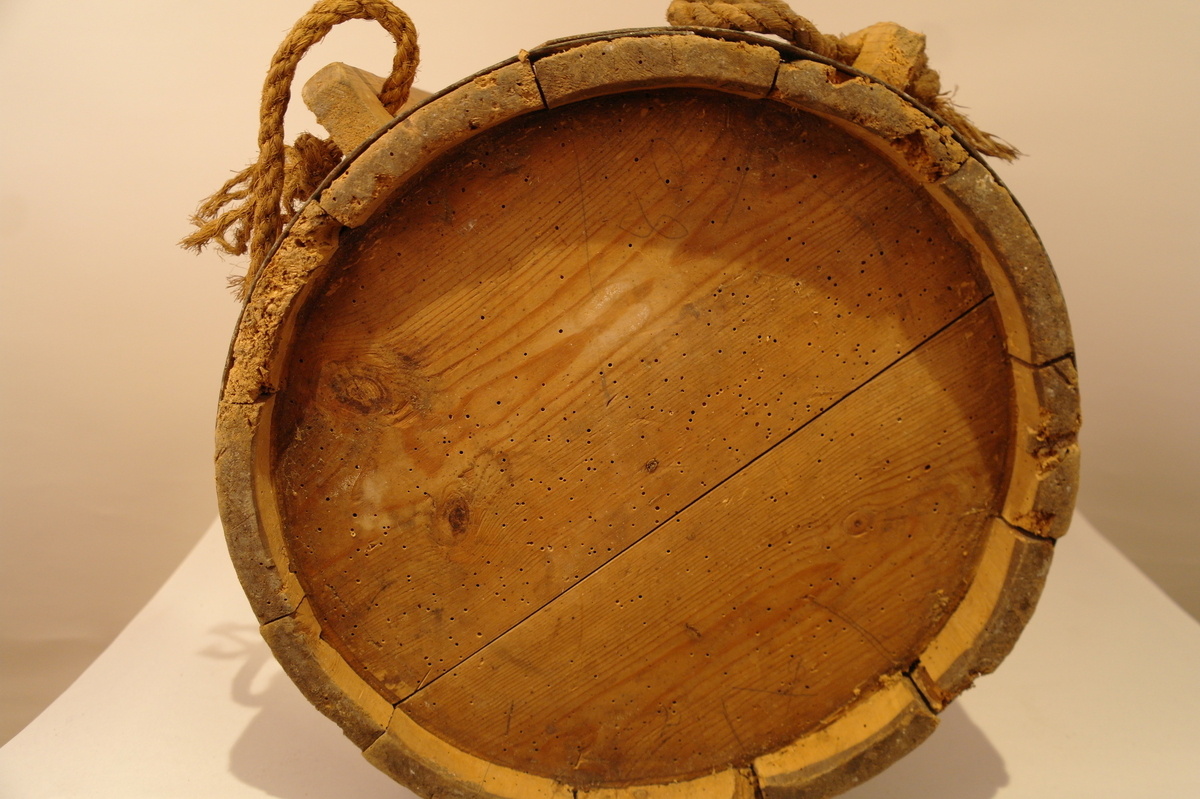 Ryggabøtte lagga av 12 stavar og haldt saman av 3 sinkband og eit laust treband på toppen. Sinkbanda er festa med spikrar. Stokkane til bæreanordningen er tappa fast til karet med trenaglar. To tau er festa til bæreanordningen. Sylindrisk. Hol etter mit, men ellers i god stand.