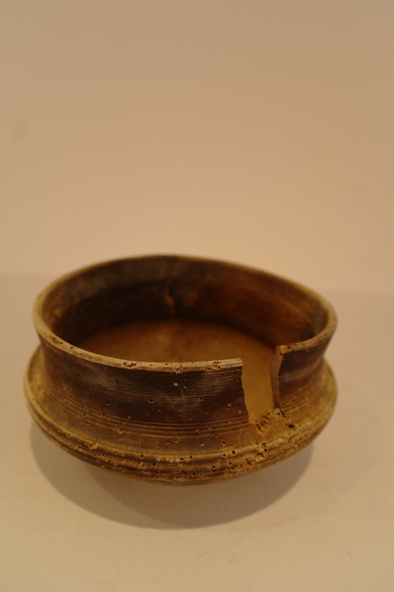 Dreiet bolle i tre. Sirkelforma munningsrand. Frå munningsranden svinger karet svakt innover, for så å svinge ut i ein vulst. Denne går over i eit lite sprang. Karet går så rett inn til fot. Ein bit mangler ved munningsranden.