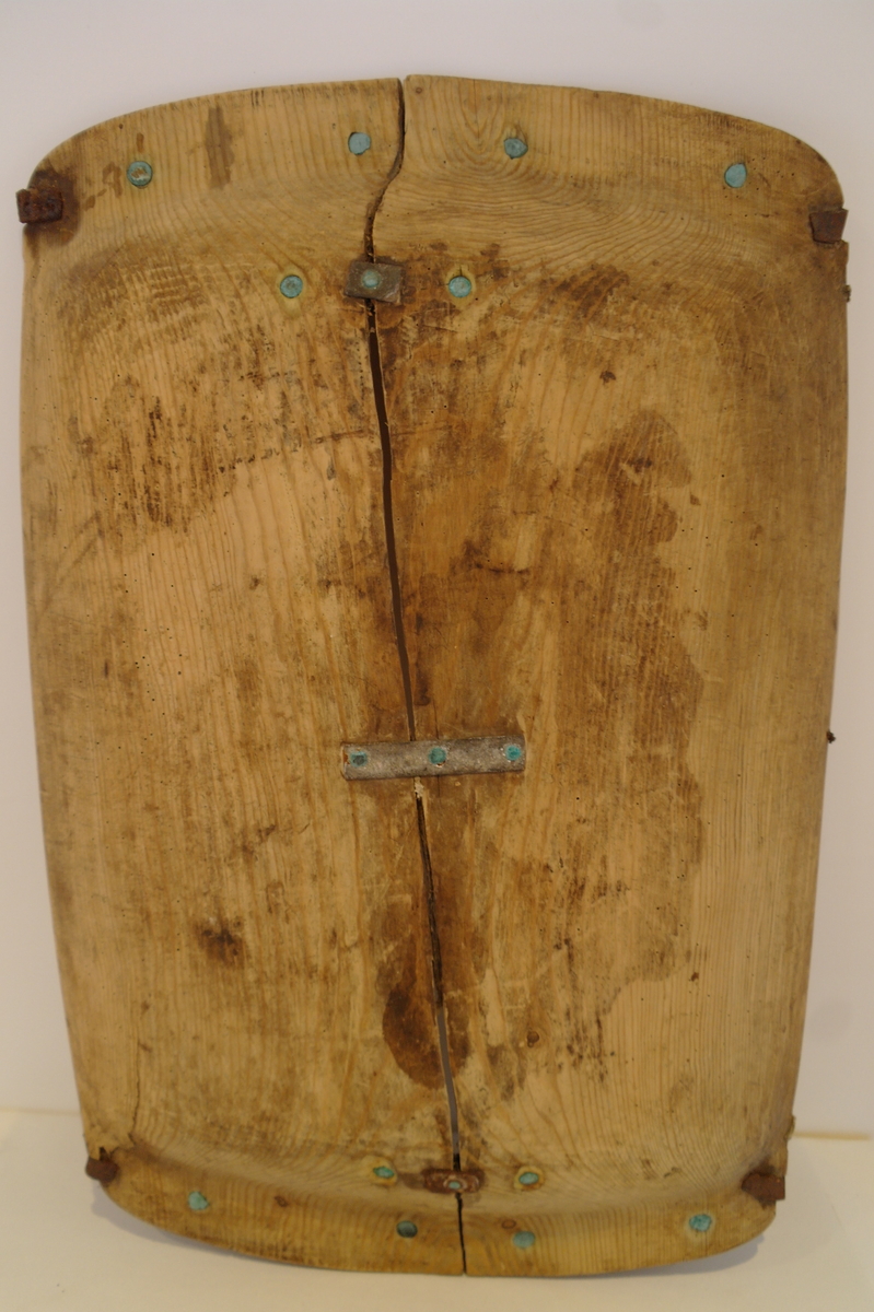 Trau i tre. Hola ut av eit stykke. Rektangulær og med runda buk. Handtaka på kortsidene er beslått med jarn. Ein stor sprekk går på langs frå handtak til handtak. Den er reparert med tre jarnbeslag. På den ene langsida er det satt på eit "skvettbord" festa med tau og spikrar.