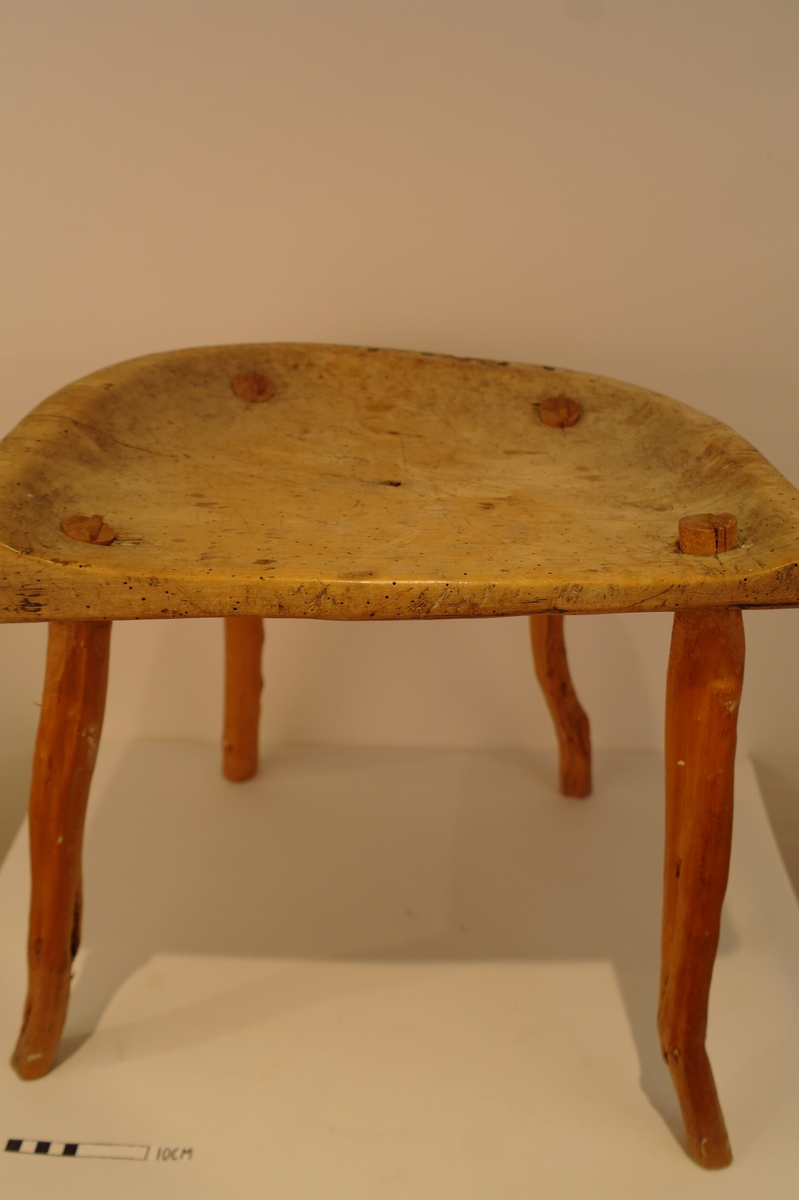 Trekrakk med fire bein. Beina er tappa i setet. Dei er skåra i eit stykke. Fire spikarslag i rygg. Bein i naturleg form etter meterialet. Beina er av nyare dato. Truleg melkekrakk ut i frå utforming. I god stand. Nokre hol etter mit.