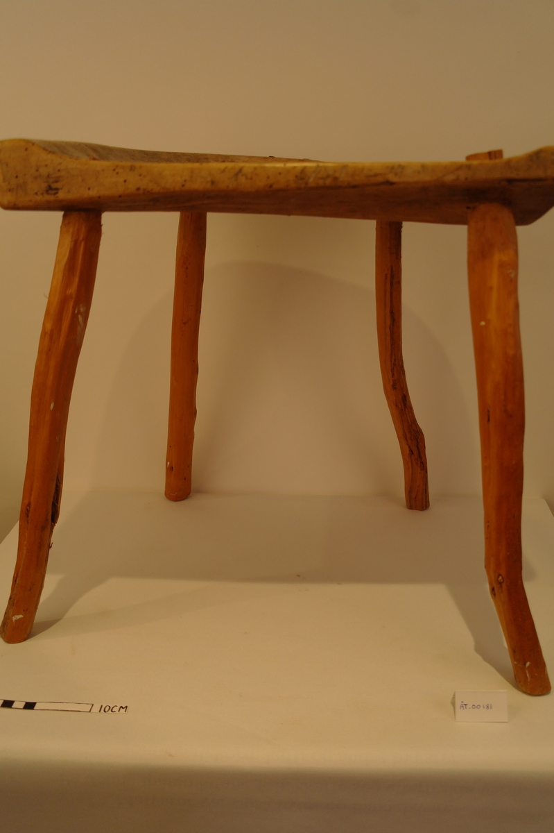 Trekrakk med fire bein. Beina er tappa i setet. Dei er skåra i eit stykke. Fire spikarslag i rygg. Bein i naturleg form etter meterialet. Beina er av nyare dato. Truleg melkekrakk ut i frå utforming. I god stand. Nokre hol etter mit.