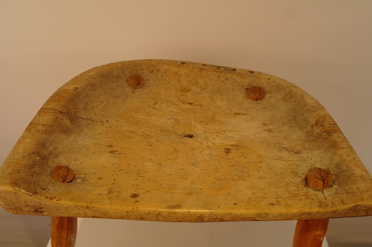 Trekrakk med fire bein. Beina er tappa i setet. Dei er skåra i eit stykke. Fire spikarslag i rygg. Bein i naturleg form etter meterialet. Beina er av nyare dato. Truleg melkekrakk ut i frå utforming. I god stand. Nokre hol etter mit.