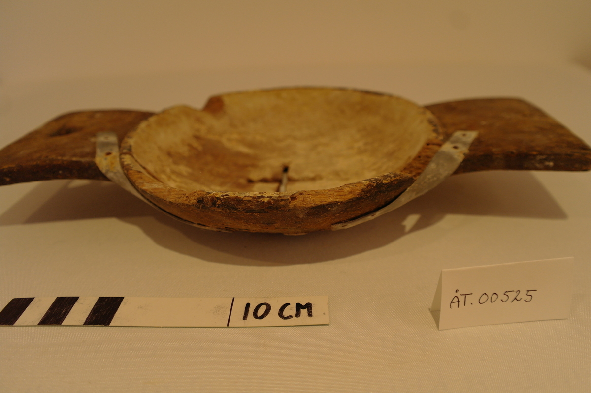 Liten mjølkesil i tre. Skåret frå eit stykke tre. Det er ein rund bolle i midten med eit hol forma som eit kross der mjølken skal silast igjennom. På kvar side av bollen er det handtak. Det eine handtaket har eit trekanta hol for oppheng. Det er ein stor sprekk i silen som er reparert med metallband som er spikra fast. Er prega av bruk og har to hakk i munningen.