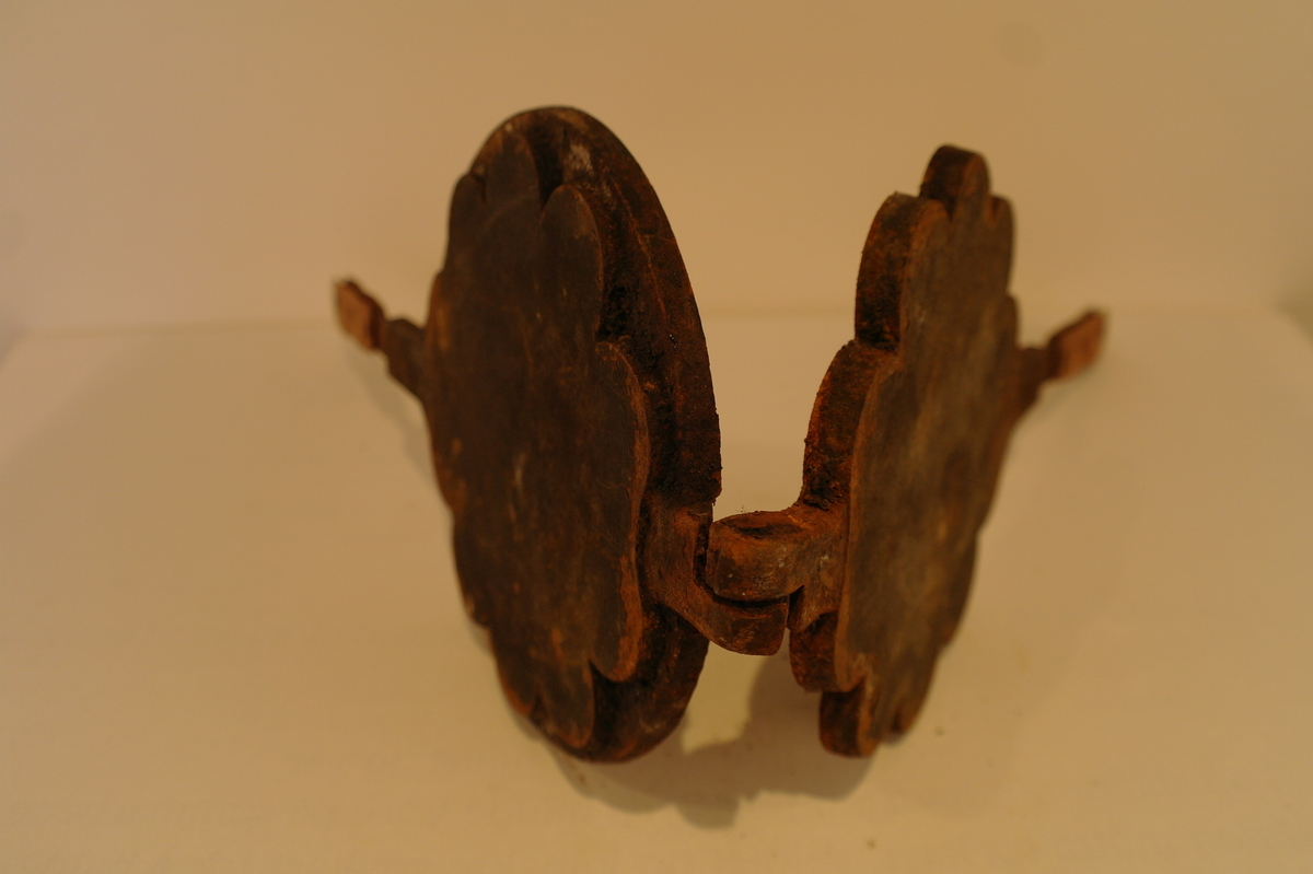 Vaffeljarn i jarn til bruk over vedovn. Produksjonsstempel:MUSTAD. På handtakene er det festa noko som liknar lær  med jarnnaglar. Innvendig er jarnet noko rusta.