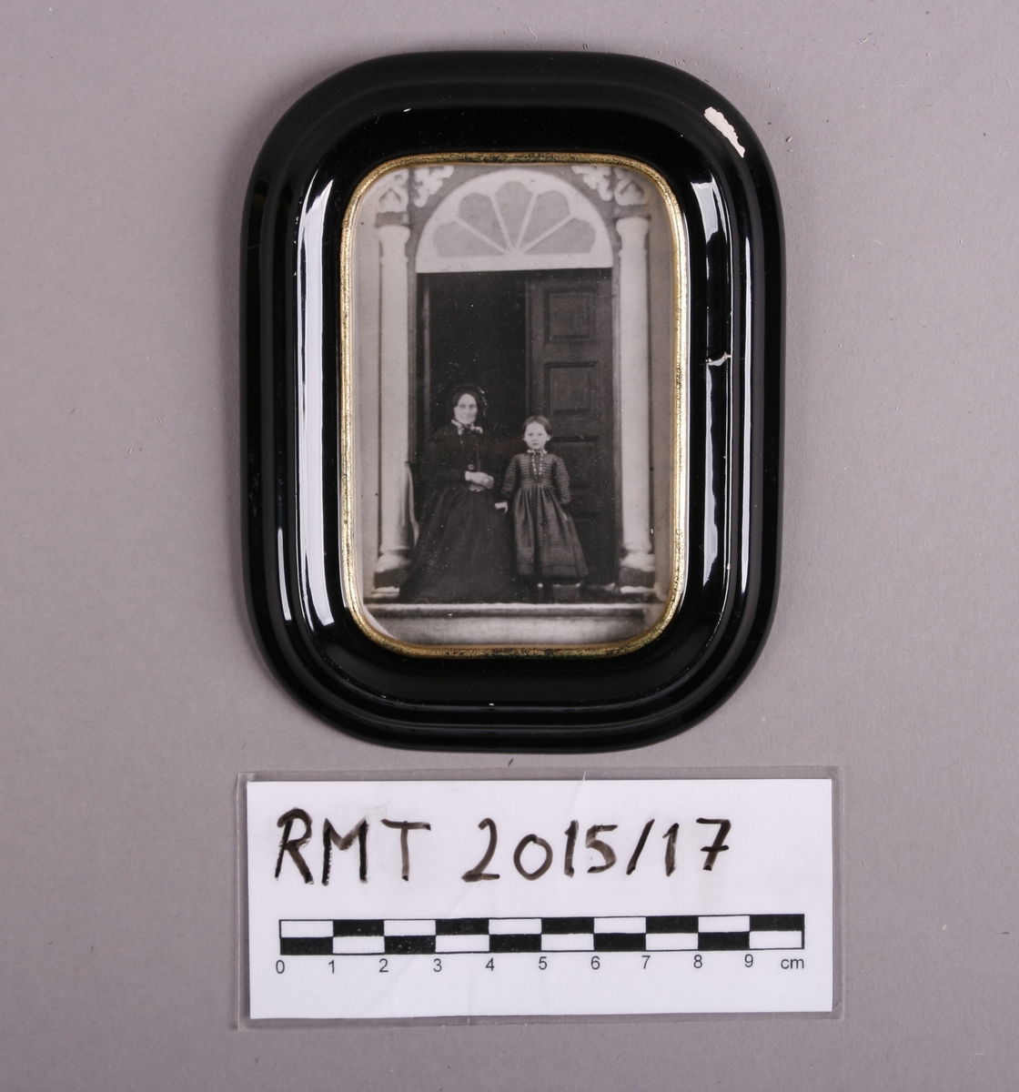 Kvinne og barn fotografert i døråpning.