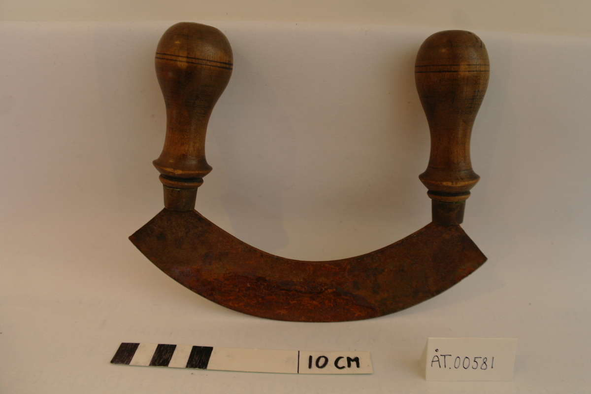 Kjøtthakke i jarn med to dreia trehandtak.