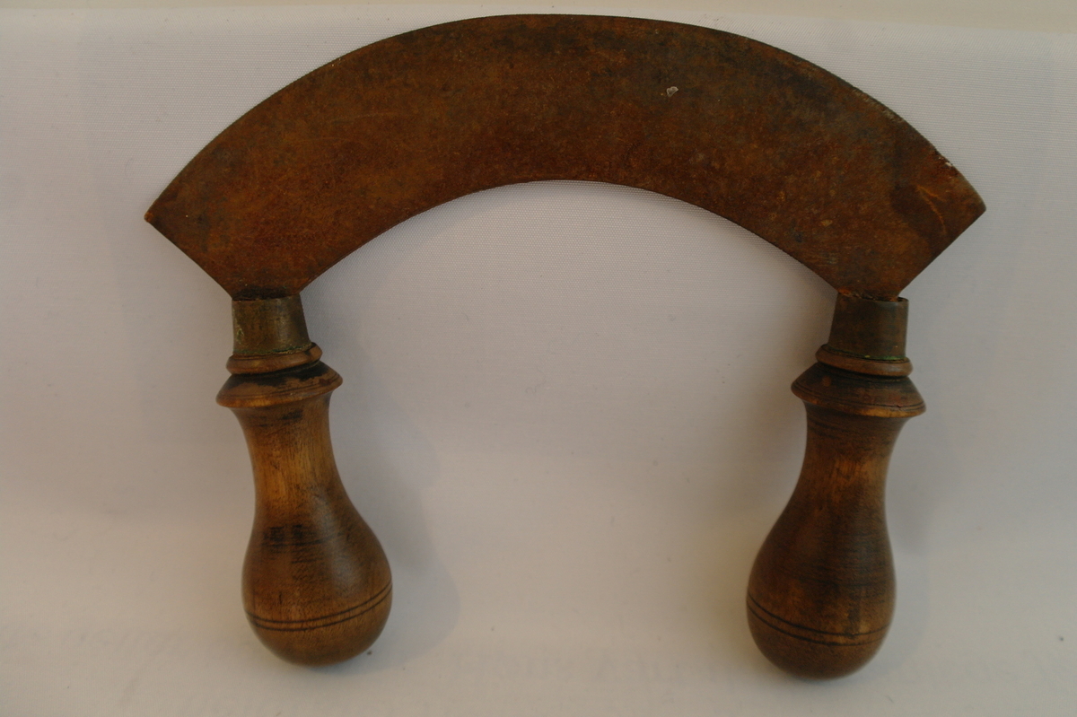 Kjøtthakke i jarn med to dreia trehandtak.