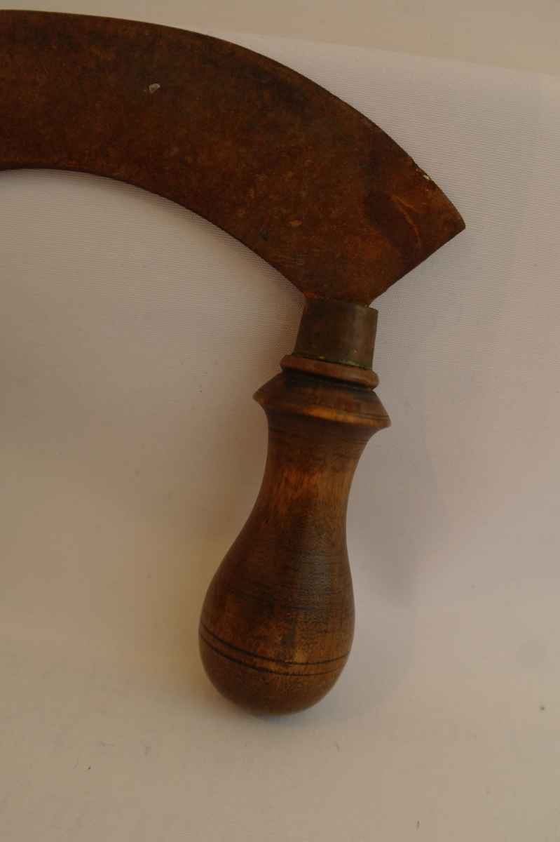 Kjøtthakke i jarn med to dreia trehandtak.