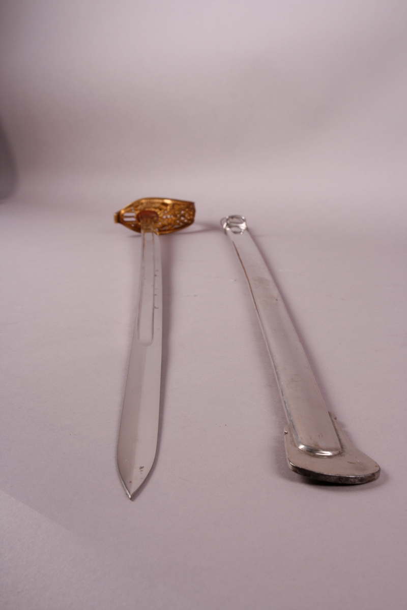 Sverd i metall med håndtak, i slire.