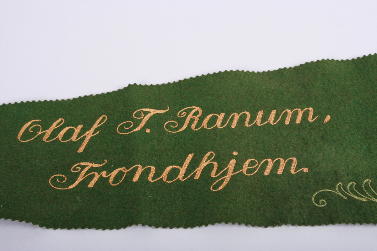 Filtduk til beskyttelse av en fiolin lagt i kasse.
Duken er dekorert med bokstaver og en lyre.