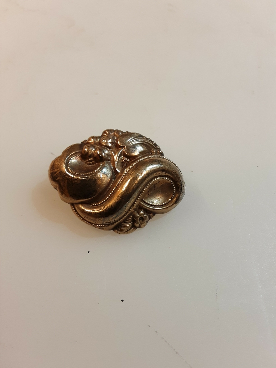 «I gamle dager » ble det laget smykker av tynt gullblikk over harpikskjerne, som hengesmykket og brosjen her. Metoden er fremdeles i bruk for å spare på det edle metallet. K. A. Rasmussen Edelmetallindustri HAMAR lager slike og lignende råprodukter til videre bearbeiding.(årsberetning H&D 1967)