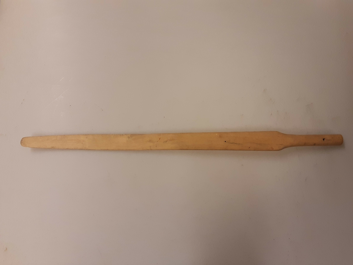 Løvtre, et emne. Skaft i en ende med hull for opphengning. Fløy svakt buet på hver side .
