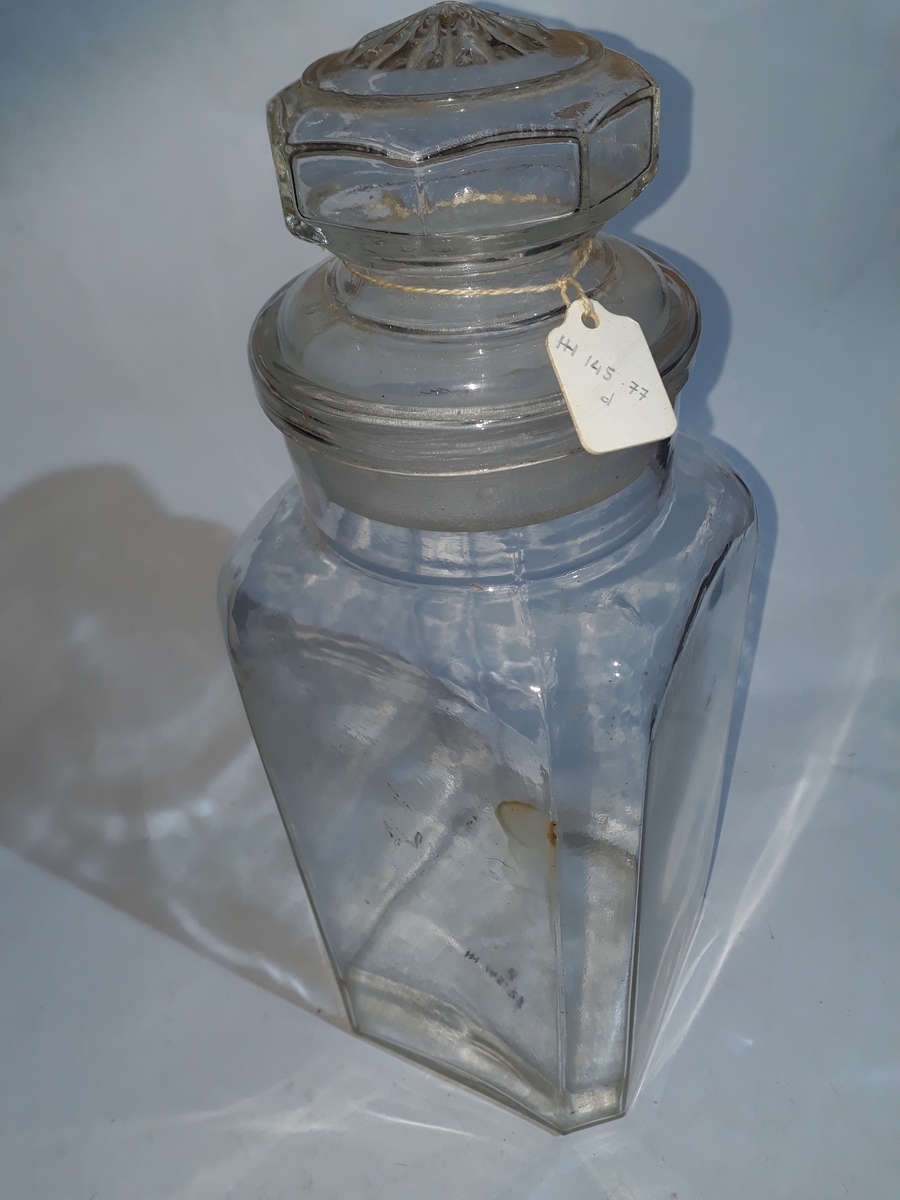 a) Standfl. sirkulær, merket "BRITISH MADE". Fire sideflater. Avrundede hjørner, rund hals.
Lokk rundt m/kuleformet håndtak. Lokk merket "2".
b) Fire store sideflater. Hjørnene er avfaset slik at det dannes fire mindre sideflater. Hals er rund. Lokk med åttesidet håndtak. Toppflate lokk m/12-bladet rosett. Etikett på sidefl. merket "Freia Drops", "fin og forfriskende". Forøvrig er det avbildet en del frukter på etiketten.
c) Formet som b, bortsett fra at rosetten på toppen av lokket er mindre, og har 16 blad. Etikett som b (noe slitt).
d) Som c.
e) Som c.
f) Fire store sideflater. Hjørnene avfaset slik at det dannes fire mindre sideflater. Den største sideflata tjener som standflate. Hals skråstilt på endeflate. Lokk, rundt merket "Freia". Håndtak på lokk er kuleformet.
g) Som f. Inneholder tørket appelsinskall.