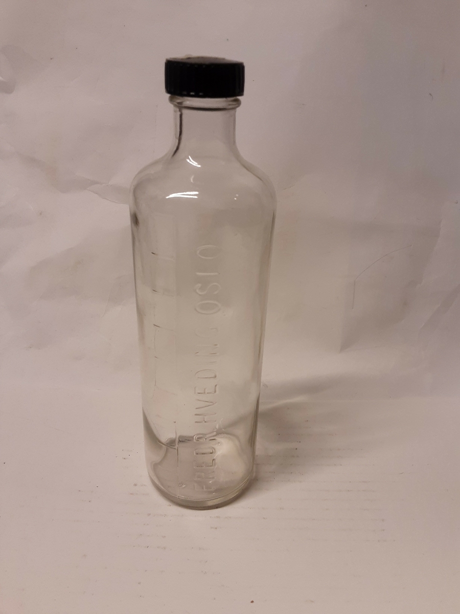 Klart glass, inndelt i ti deler. Skrukork av svart bakeIitt.