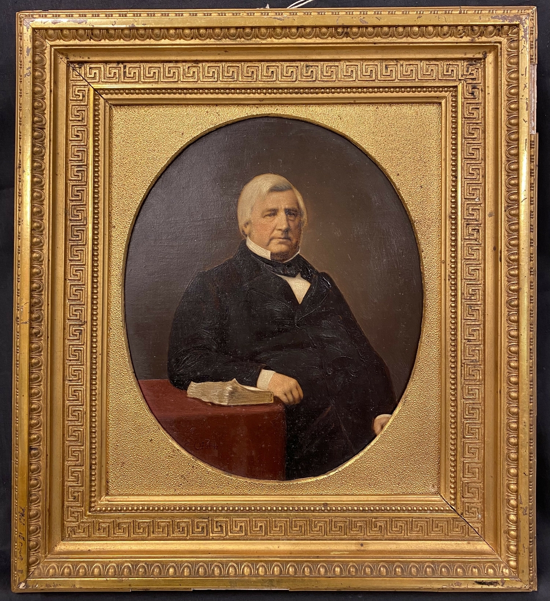 Portrett av Christian Julius Schou. Trekvart profil vendt mot høyre og blikket hviler til høyre for betrakteren. Halvfigur, sittende. Hans venstre albue og arm hviler på en bok, på et bord med rød duk. Mørk jakke, hvit skjorte med mørkt tørkle i halsen utenpå kragen. Mørk brunlig bakgrunn.