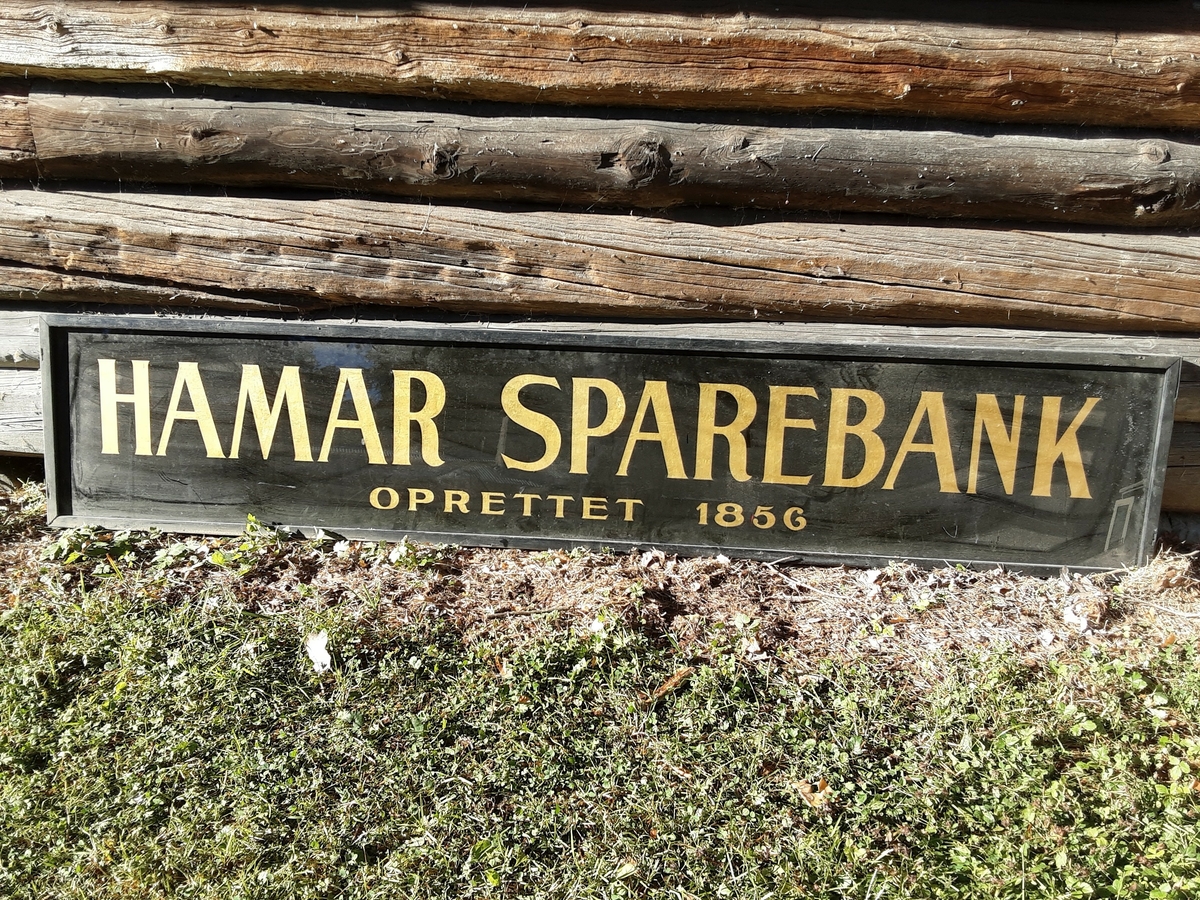 2 avlange skilt med treramme. Glassflata er malt på baksiden.