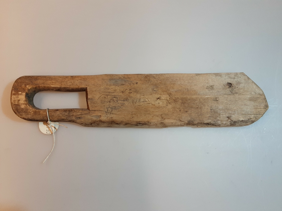 Form: Flat, uhøvlet med håndtak på midten. 
