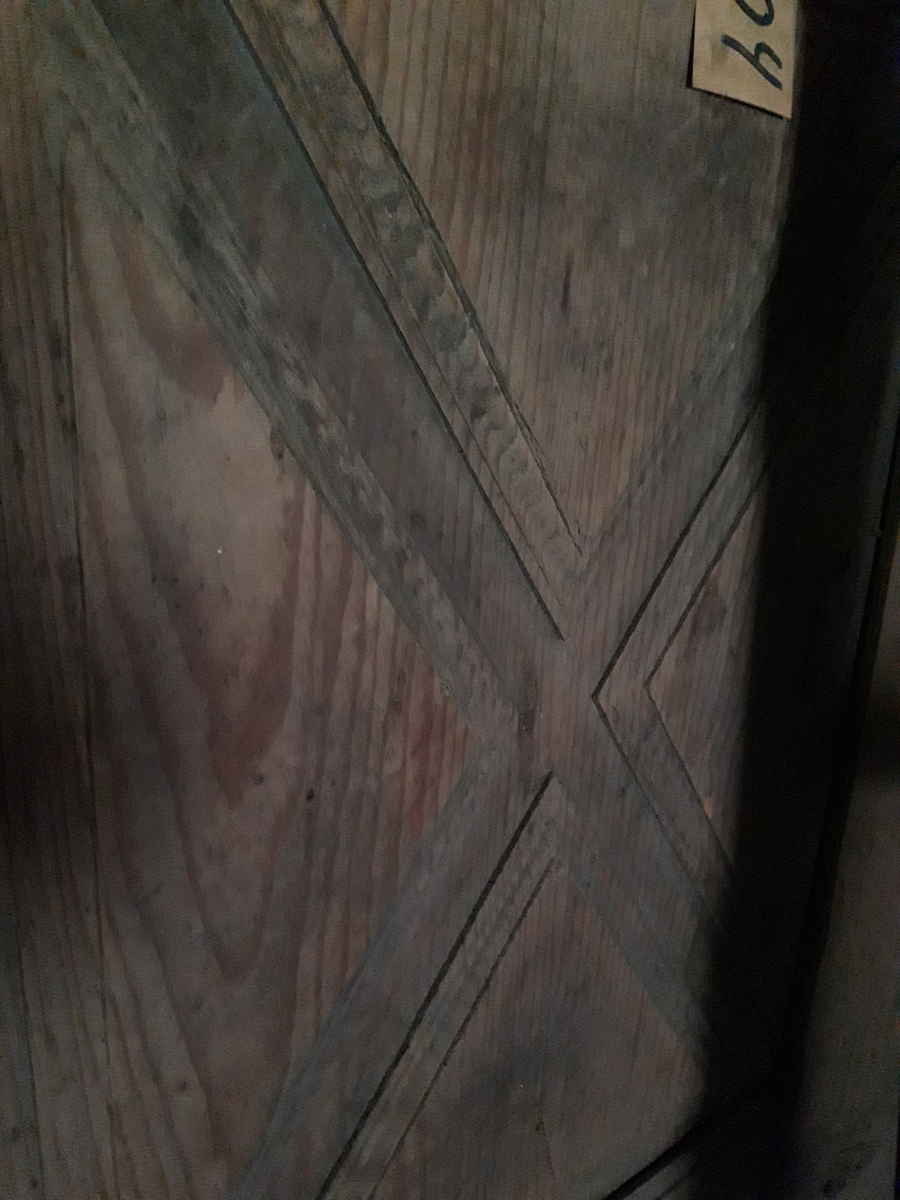 Senga består av 2 sider. Den er laget med rammeverk og fyllinger i dypt relieff.. Mangler noe av venstre sides panel og hjørnedekor på høyre side.