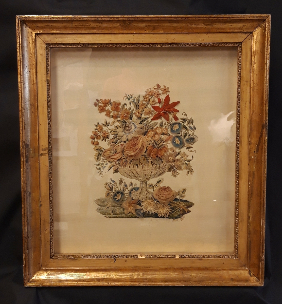 Blomstervase brodert på silke. Innrammet i forgyldt ramme med glass.