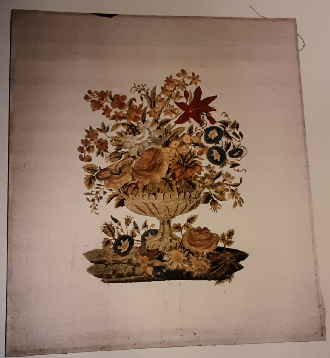Blomstervase brodert på silke. Innrammet i forgyldt ramme med glass.