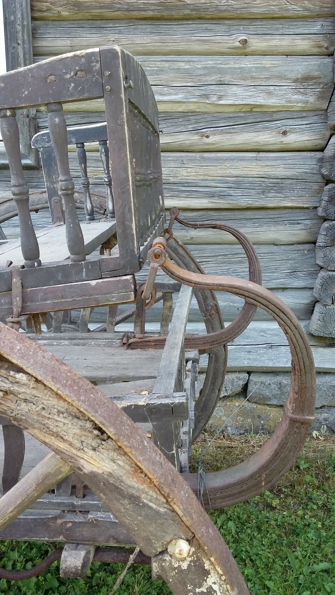 Vogn med to hjul, stol i c-fjærer foran og bak (sviktende trefjærer), ett tverrstilt sete (dreide spiler). Slett kassebunn med flate svakt s-formete spiler. 
Greaseaksel.
Jernbeslåtte hjul.
Antall trefell: 6
Antall eiker: 12
Det er rissa to tynne stafferingsstreker på hjulene og med vulst på innsida.