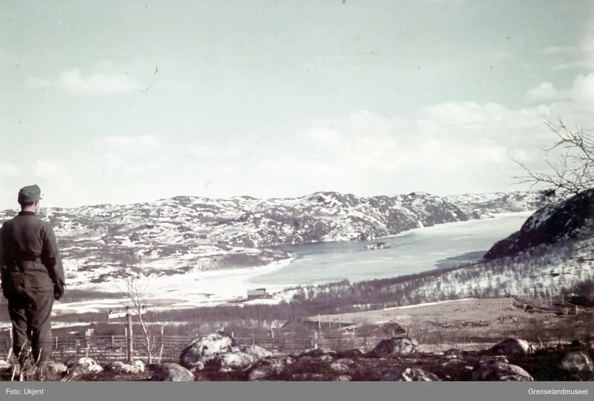 En soldat står ved Høybuktmoen og ser utover Strømsbukta i Langfjorden mot Sandnes.