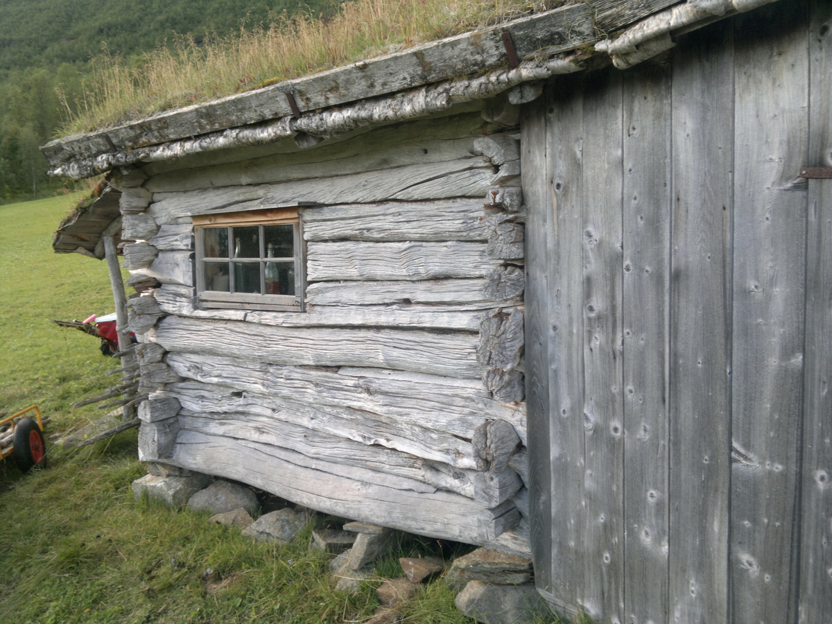 Masstue. Steinmur på grunnen, to laftet av rund tømmer med reisverk mellom byggene. Takåser, tro, næver og torv. Første bygning på Bredek, da brukt både til bolig og fjøs. 
