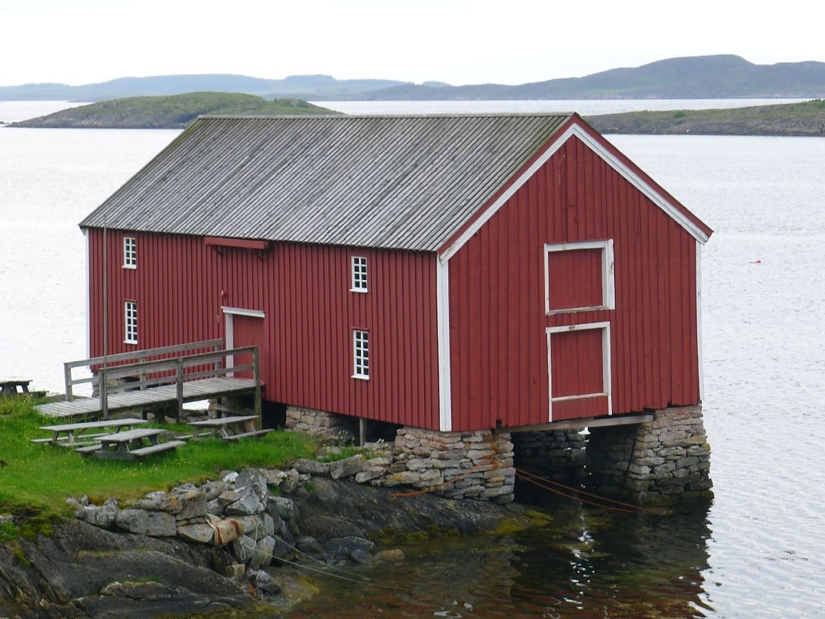 Rødmalt brygge på stabber av murt stein. Bordkledd og bordtak. 137 m2 grunnflate, totalt areal 240 m2. 