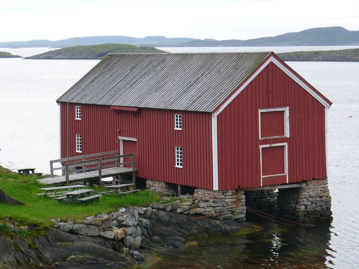 Rødmalt brygge på stabber av murt stein. Bordkledd og bordtak. 137 m2 grunnflate, totalt areal 240 m2. 
