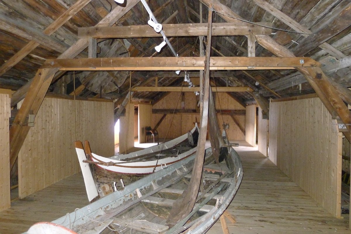 Rødmalt brygge på stabber av murt stein. Bordkledd og bordtak. 137 m2 grunnflate, totalt areal 240 m2. 