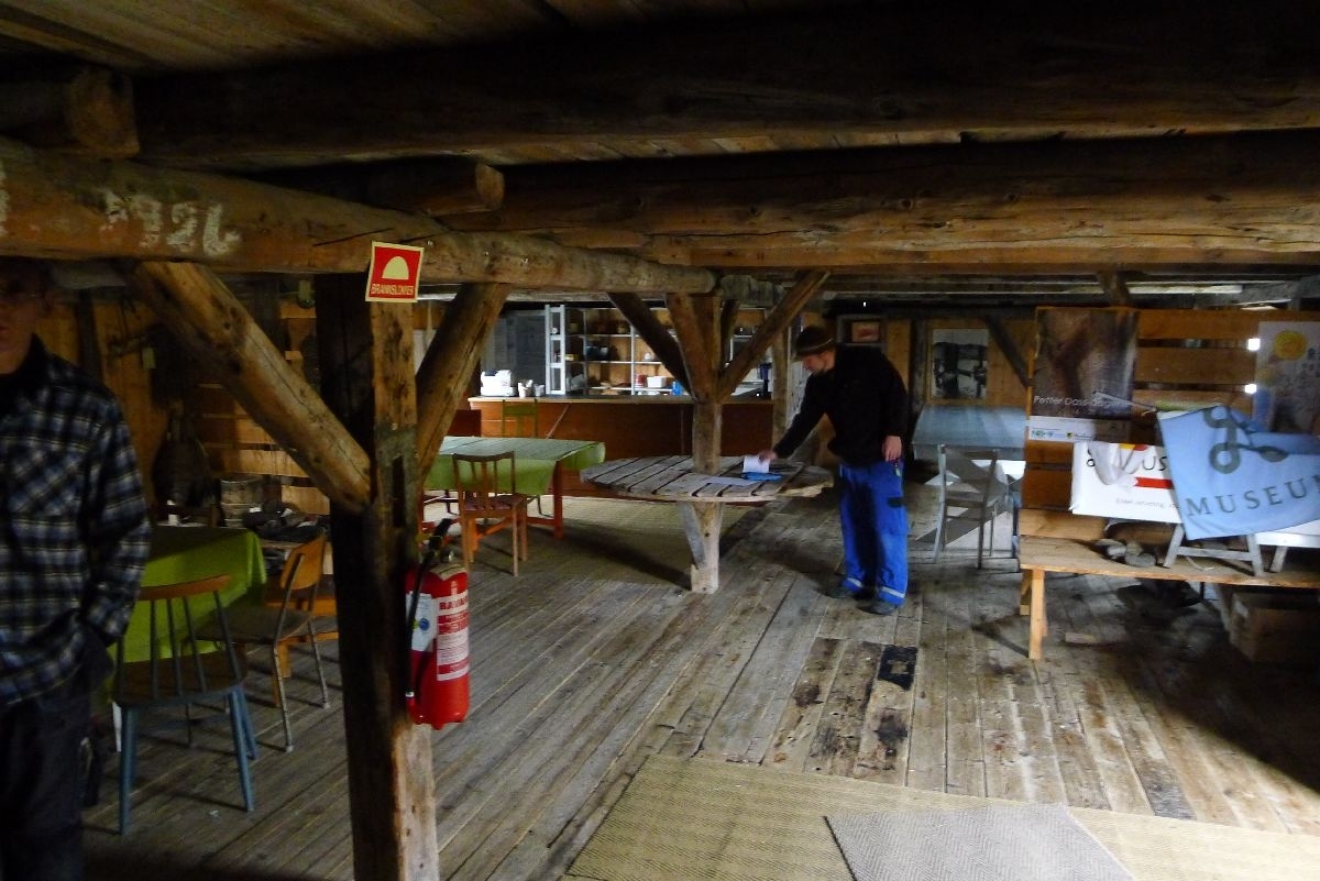 Rødmalt brygge på stabber av murt stein. Bordkledd og bordtak. 137 m2 grunnflate, totalt areal 240 m2. 