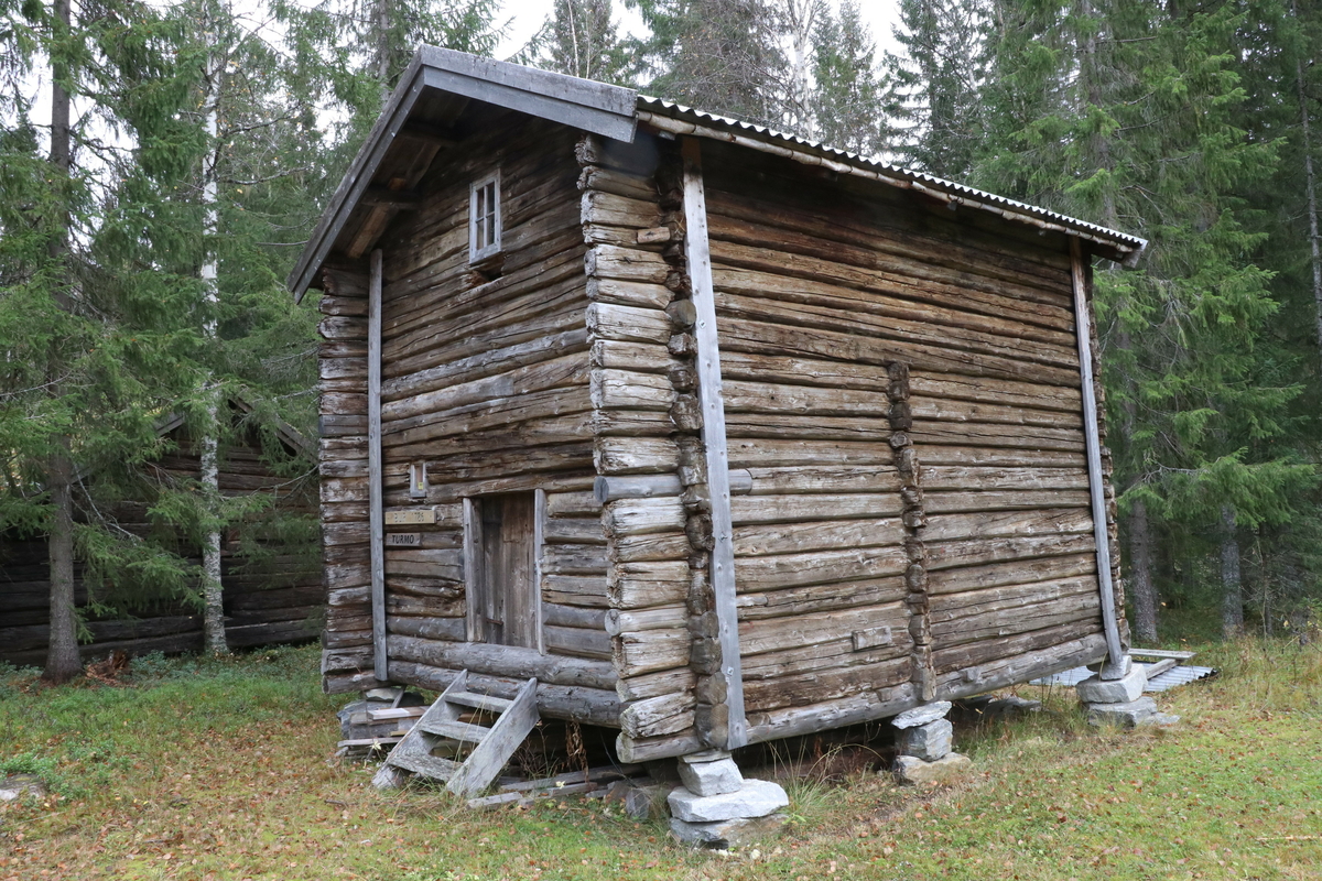 Bur fra gården Turmo, Grane bygd ca 1786. Laftet, har to etasjer. I første etasje er det to rom. Innerrommet har to arbeidsplater og en stor melkiste. Fremre rom har to veggfaste senger. Trapp til loft i innerste rom. Bygningen har i dag to vinduer. 