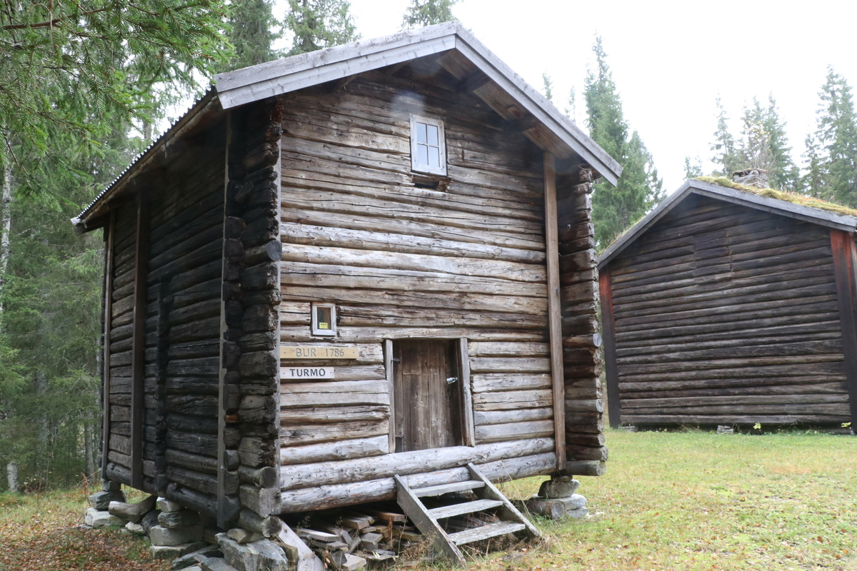Bur fra gården Turmo, Grane bygd ca 1786. Laftet, har to etasjer. I første etasje er det to rom. Innerrommet har to arbeidsplater og en stor melkiste. Fremre rom har to veggfaste senger. Trapp til loft i innerste rom. Bygningen har i dag to vinduer. 