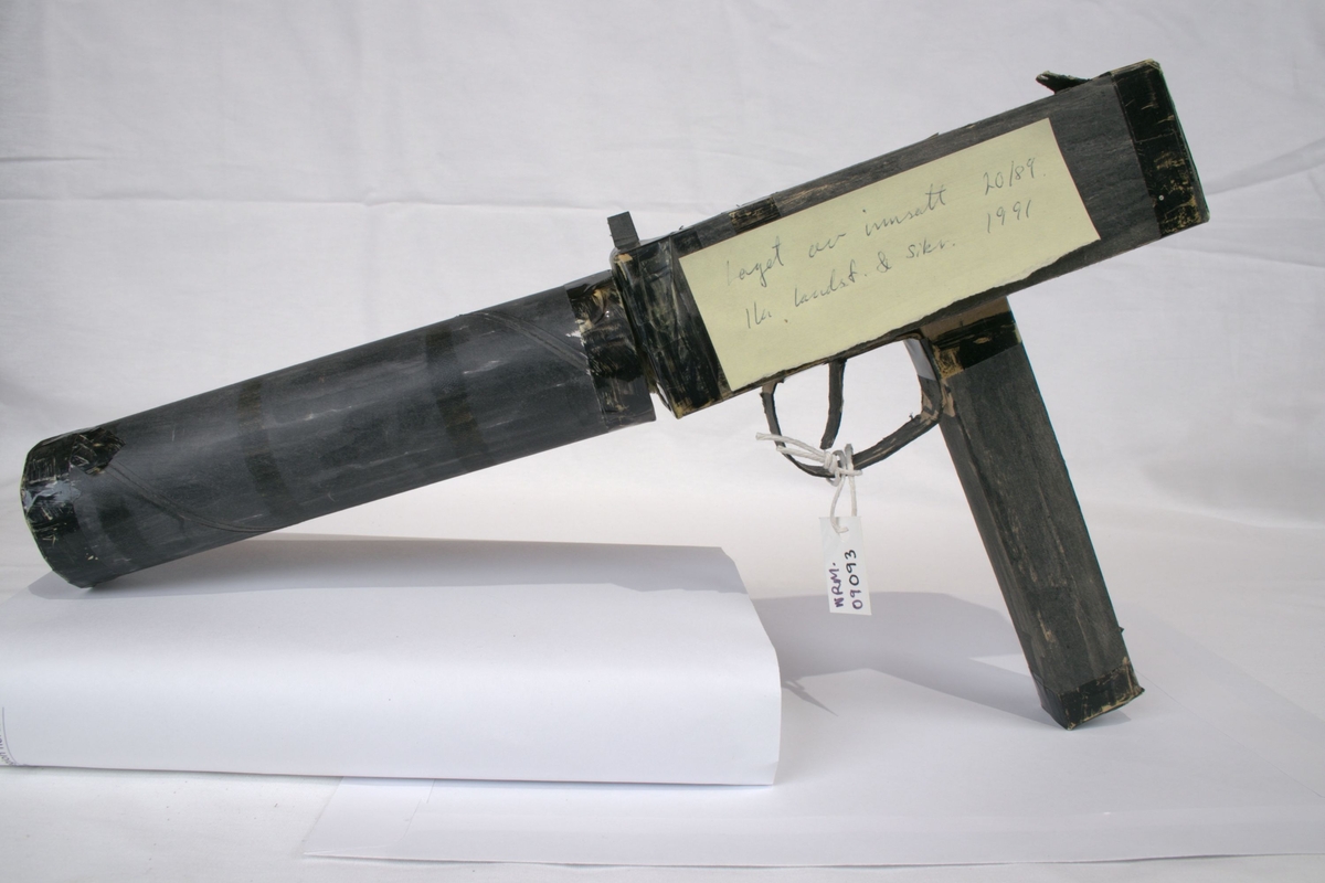 Falskt våpen i sortmalt papp som skal ligne en Uzi maskinpistol.