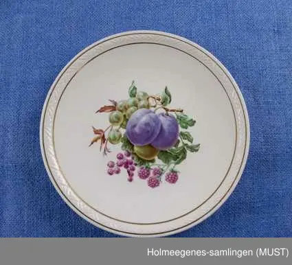 Fruktmotiver, gull-staffasje, støpt bord langs kanten.