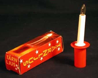 :1 Batteridrivet ljus av plast bestående av en hylsa av röd hårdplast som fungerar som behållare för ett batteri. Ovanpå placeras det 100 mm höga ljuset i vit plast med glödlampa på toppen som lyser med hjälp av batteriet. Ljuset tänds och släcks genom att man skruvar på lampan.
:2 Rektangulär kartong, längd: 175 mm, bredd: 50 mm, i vilken ljusets köptes i. Av röd papp, på utsidan ett fotografi av ett lysande ljus. Med vit tryckt text står: "Tärnljus. Tärnljuset har ett 10 cm vitt ljus med röd batterihållare. Topplampa 1,4 V. Alla batterifabrikat passar. Kontaktfjädern skall löpa i ett av de två spåren som finns i batterihållaren. Lampan används för att tillfälligt tända och släcka tärnljuset. Avlägsna alltid batterite efter användande genom hålet i botten på batterihållaren. OBS! Låt aldrig barn stoppa ljuset i munnen! Hooks belysning AB 551 11 Jönköping.".