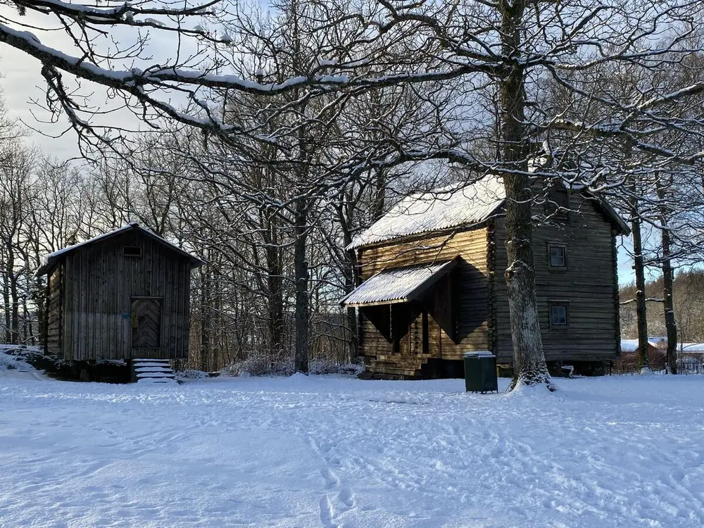 To stabbur på tun dekket av snø