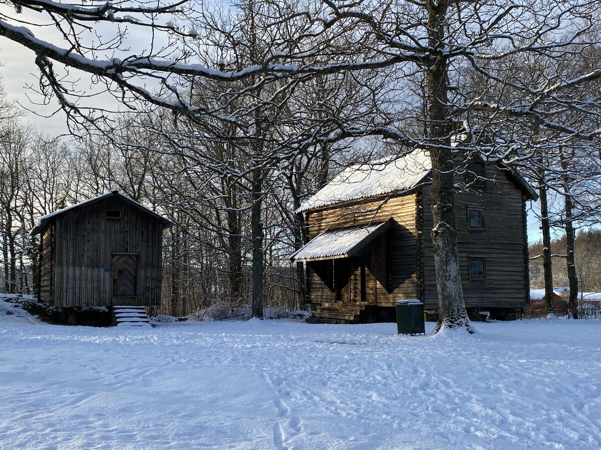 To stabbur på tun dekket av snø