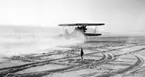 Flygplan Sk 10 startar från ett snötäckt flygfält. Vy bakifrån. Cirka 1932-1939.