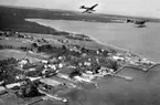 Flygbild av två flygplan S 5, Heinkel He 5 Hansa över kust. Flygplan 2452 och 1470. Eventuellt är platsen Fårösund. 1930-tal.