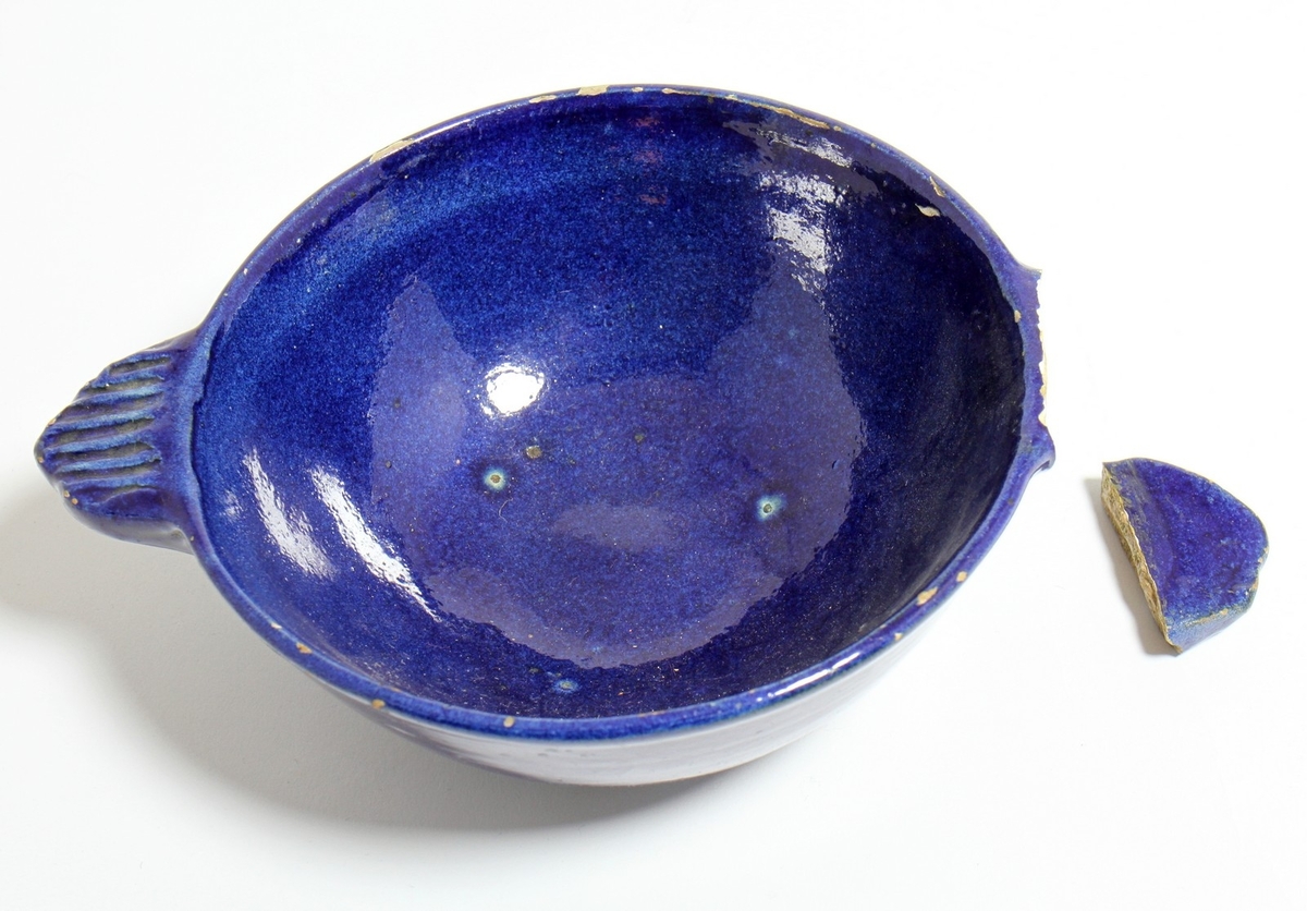 Blå keramikkskål som har tilhøyrt diktaren Henrik Rytter (1877-1950). Skåla kjem frå Rytter sin eigedom "Rytterhaugen". Den eine hanken på skåla er avbroten.