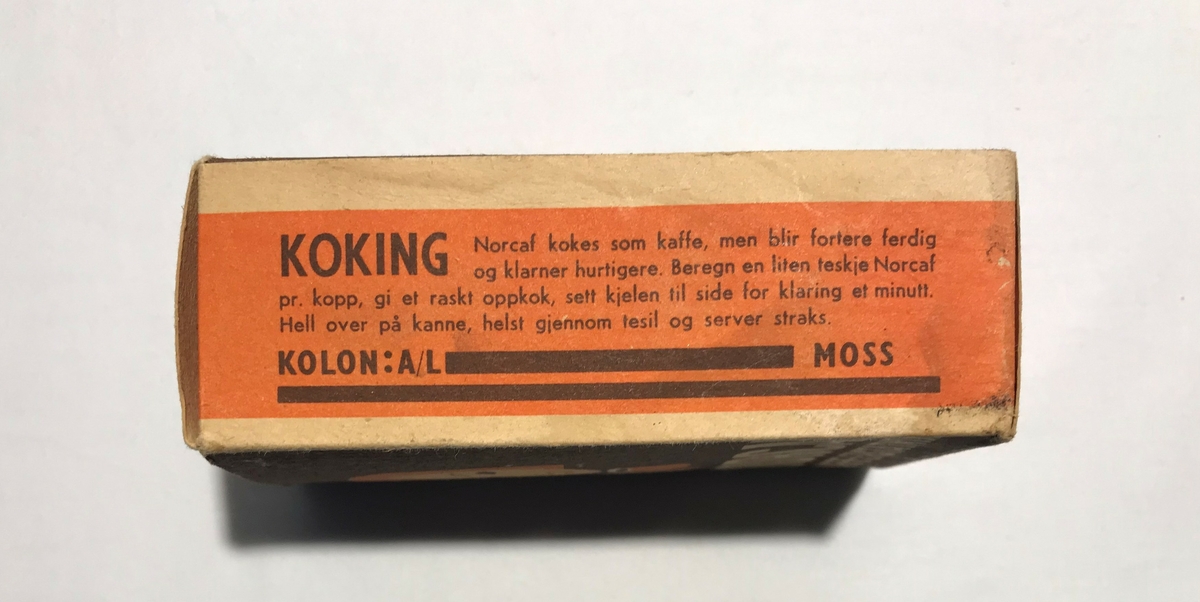 Eske av papp med kaffeerstatning. Tekst: NORCAF KAFFE ERSTATNING. På sidene står bruksanvisning på tilbereding for koking og trakting. Kaffeerstatningen ligger i esken i en papirpose.
Tidligere 2stk. Et i brygge og et i Våninghuset. Gjenstanden i brygga ble oppspist av mus og destruert under opprydning Juni 2024