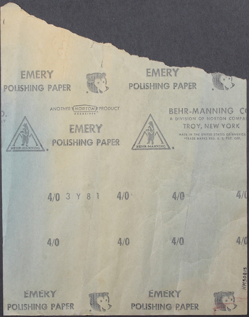 Polerpapper med brun ovansida. Pappret har rektangulär form med en avriven bit upptill.