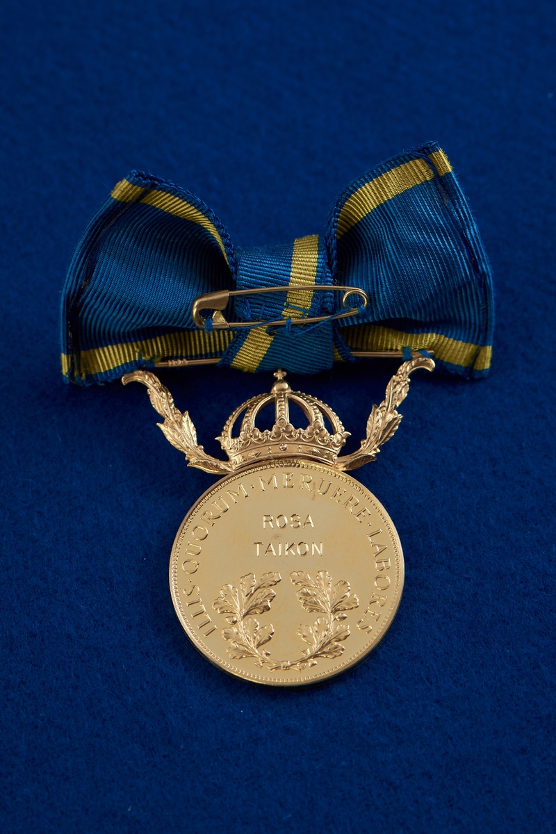 Medalj i guld fäst på blågult band i formen av en rosett. Ovanför den runda medaljen finns en krona mellan två kvistar. År 2010 erhöll Taikon regeringens guldmedalj Illis quorum meruere labores för sitt betydelsefulla konstnärskap “som förenar nyskapande smyckedesign med romska smidestraditioner.” Medaljen överlämnades av dåvarande kulturminister Lena Adelsohn Liljeroth.