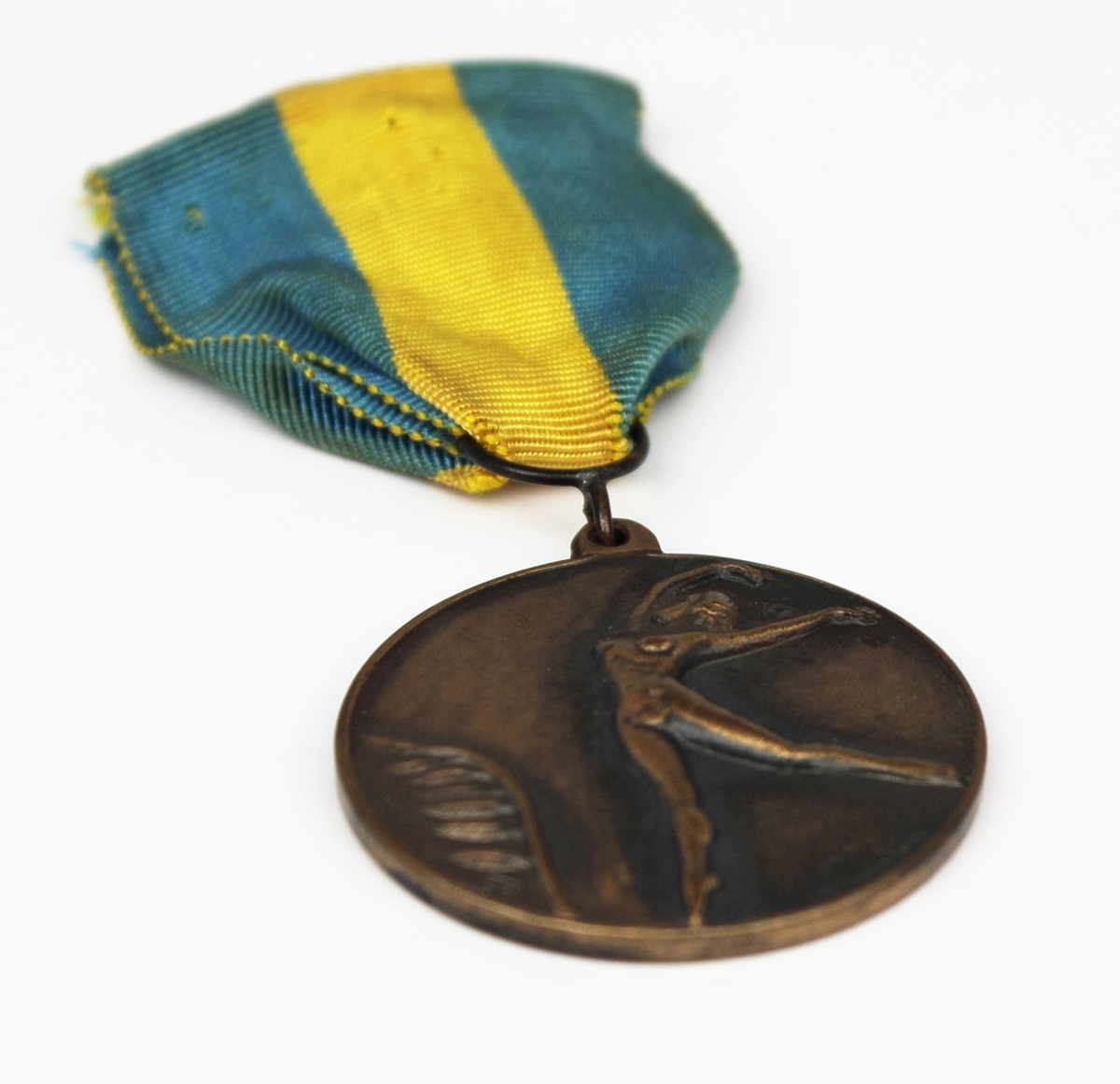 Medalj i brons fäst på blågult band. Medaljen har rund form med en naken kvinna i relief på framsidan. Medaljen var förstapriset i skönhetstävlingen "Tusensköna" på Nalen år 1949 och tilldelades Rosa Taikon. Priset var på 1000 kr.
