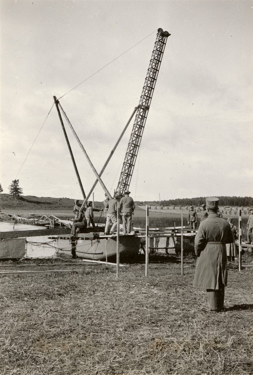 Text i fotoalbum: "Brobyggnad i Storvreta under mötet 1931. Vi började med att reda pålkran och slogo ned långa pålar".