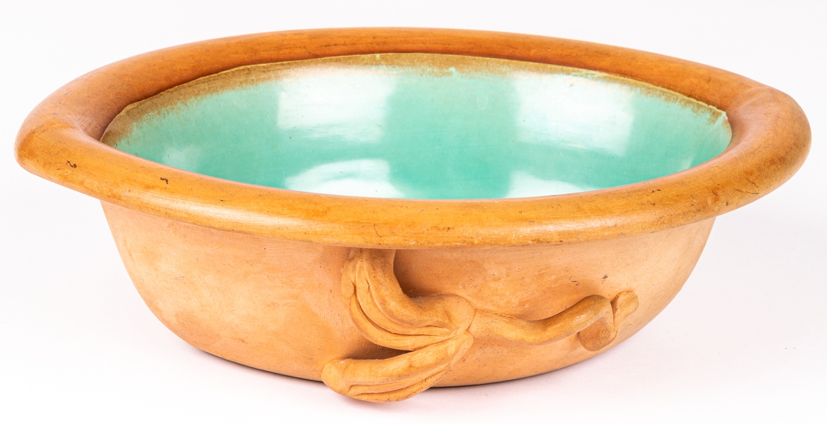 Oval skål, halvglaserad, utsida med pålagda blad, insida turkosgrön glasyr.