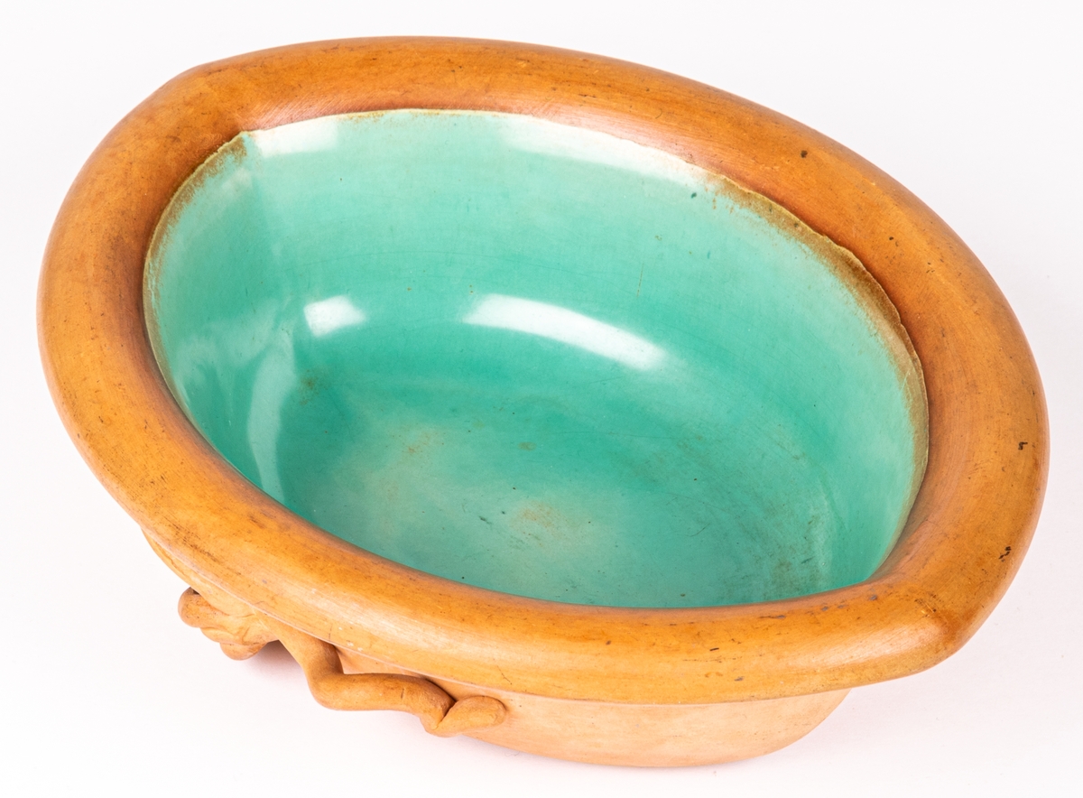 Oval skål, halvglaserad, utsida med pålagda blad, insida turkosgrön glasyr.