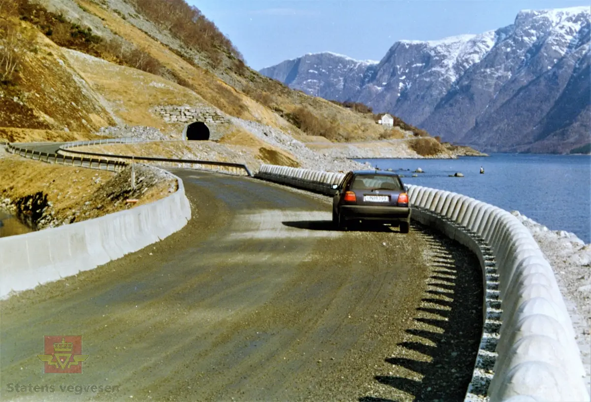 Rassikringstiltak ved Breidesvadet på fylkesveg 65 Festøya - Standal i Ørsta kommune.

Et forsøk med et spesielt rekkverk med tanke på at snøens skulle drive over vegen. I bakrunn ser en det 129 meter stålrørtunnelen/rasoverbygget ved Langeneset.
(Informant: Pensjonerte ansatte i Statens vegvesen i Møre og Romsdal.)

I vegperioden 1986-89 ble det avsatt 9 millioner kroner (1986-kroner) til rassikring på fylkesveg 65, Standal-Festøy. Dette var en stor og samtidig interessant oppgave som Statens vegvesen ikke så seg i stand til å håndtere selv. Derfor ble det innledet et samarbeid med NGI (Norges Geotekniske Institutt).

En var klar over at en ikke kunne regne med nok bevillinger til en "fullgod sikring", dvs. overbygg i betong på alle snørasene på strekningen. I så fall ville dette medføre en samlet lengde på 700 meter og det vil koste ca 40 millioner kroner.

Som en konsekvens la en seg på et "akseptabelt" nivå når det gjaldt regulariteten på vegruten. En mente at en reduksjon på 70-80% totalt på strekningen i "normale" vintre var et mål en kunne håpe på.

Planleggingen skjedde i samarbeid med vegbrukerne og vedlikeholdet med mål om å sikre hele strekningen og redusere stengningene med 70-80% i en normal vinter.

(Kilde: Statens vegvesen i Møre og Romsdal sitt interne magasin "Veg og Virke" nr. 2/1990, artikkelen "Givande om rassikring i Sæbø", skrevet av oppsynsmann Arnold Hustad.)